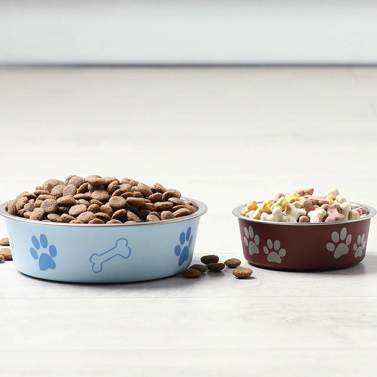 Two pet bowls placed on a clean, light-coloured wooden floor